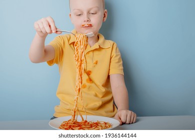 Cute Boy Eating Spaghetti Bolognese At Home. Concept Of Dirty Stains On Clothes. Isolated On Blue Background. High Quality Photo