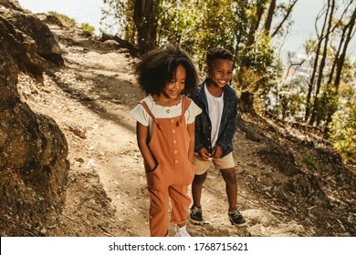 Cute boy and girl walking on a mountain trail. Boy and girl in casuals walking together on forest trail.
