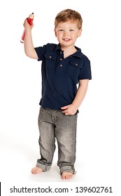 Cute boy holding a big pencil looking happy on a studio white background.