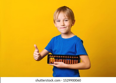 Cute boy holds abacus. Kid study at mental arithmetic school. Education and development concept