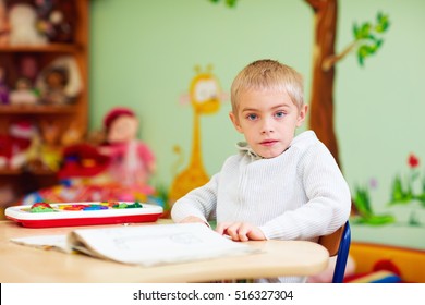 cute boy, kid with special needs learning in rehabilitation center