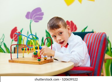 cute boy, kid in wheelchair solving logical puzzle in rehabilitation center for children with special needs