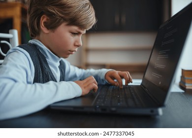 Cute boy learning to work on laptop at home