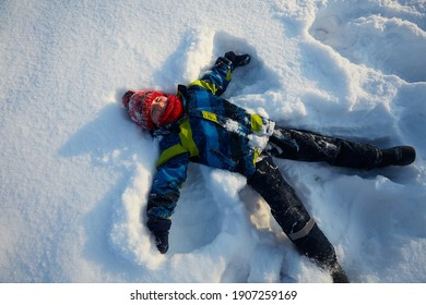 Cute Boy Is Making Snow Angel, Top View