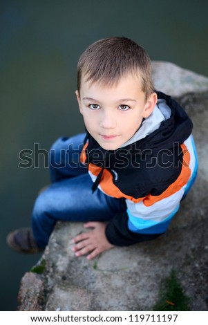 Similar – Cute little boy seated on the wall of a castle