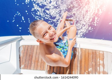 Cute Boy On Board Of Sailing Yacht On Summer Cruise. Travel Adventure, Yachting With Child On Family Vacation. Kid Clothing In Sailor Style, Nautical Fashion.