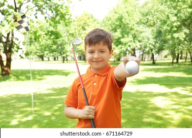 Cute boy on golf course in sunny day