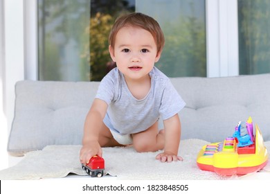 Cute Boy Playing With Car Toy At Home. Mixed Race Asian-German Infant About One Year Old In Diaper.