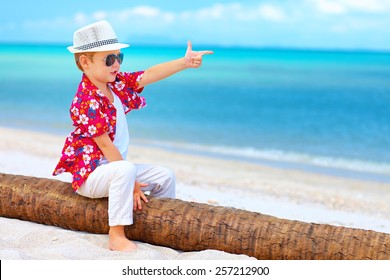 cute boy playing a gangster on summer beach