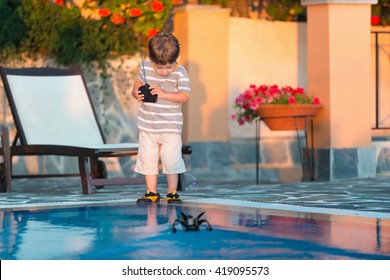 Cute Boy Playing With Remote Control Boat By The Pool