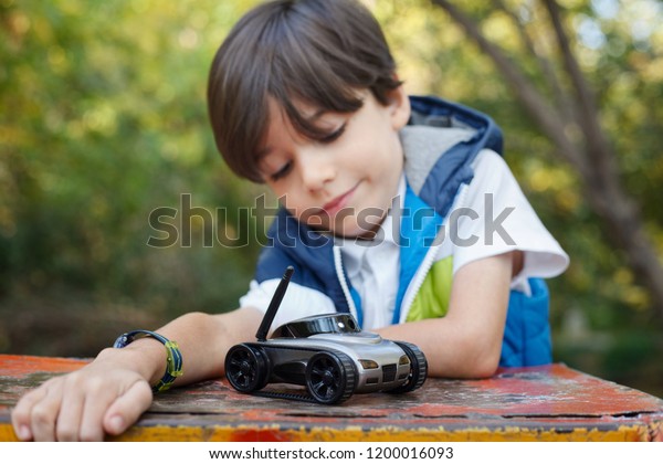 cute boy playing\
with robot car in\
playground