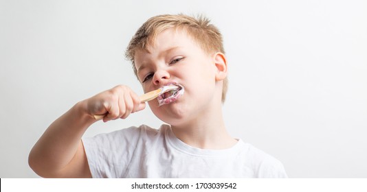 Cute Boy Posing With Bamboo Toothbrush In His Mouth, Child Brushes His Teeth