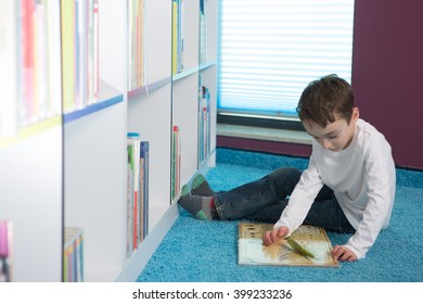 Cute boy reading book in library 
 - Shutterstock ID 399233236