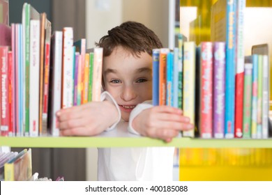 Cute boy reading book in library 

