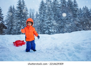 Cute Boy Run On Uphill With The Sled To Go Downhill, Over The Mountain Peaks On Winter Vacation During Snowfall