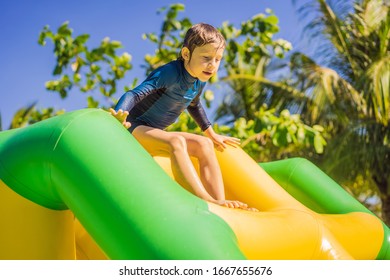 Cute Boy Runs An Inflatable Obstacle Course In The Pool