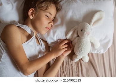 Cute Boy Sleeping In Bed. School Child Dreaming And Holding Plush Toy.