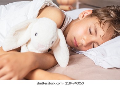 Cute Boy Sleeping In Bed. School Child Dreaming And Holding Plush Toy.