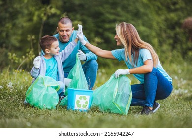 A cute boy who collects plastic waste in a forest or park with his parents, throws used plastic bottles and other garbage in the garbage can. The concept of environmental protection and ecology. - Powered by Shutterstock