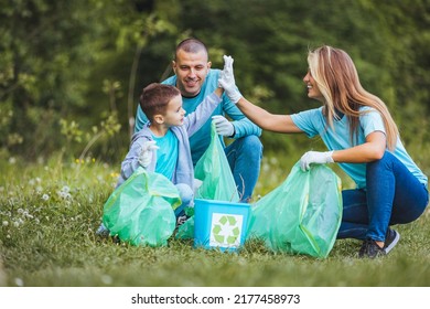 A cute boy who collects plastic waste in a forest or park with his parents, throws used plastic bottles and other garbage in the garbage can. The concept of environmental protection and ecology. - Powered by Shutterstock