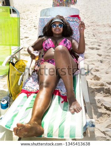 Cute Brazilian girl sunbathes on Copacabana Beach in Rio de Janeiro