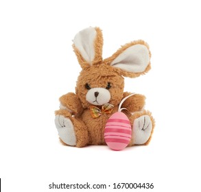 cute brown bunny and pink colored eggs on a white background, easter backdrop
