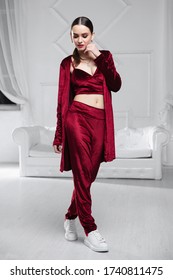 Cute Brunette Dressed In A Burgundy Velour Suit Posing In The Studio