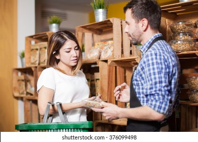 Cute Brunette Getting Some Assistance From A Store Clerk At A Local Grocery Store