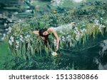 cute brunette woman long hair lies in boat  gently touches water lily her hand. princess bride dress floats on lake. Friday, sleeping relaxation enjoyment. Creative wedding decor natural cosmetics 