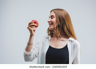 Cute brunette woman in white shirt holding red apple in hand standing on isolated white background dietetics and nutrition. Healthy food - Shutterstock ID 2183501459
