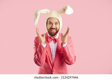 Cute bunny. Positive funny man in soft white hat with ears of rabbit and in pink suit who is sincerely happy on pink background. Concept of human emotions and Easter celebration. Banner.