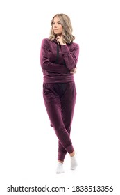 Cute Calm Young Woman In Burgundy Plush Sweatsuit Posing With Finger On Cheek. Full Body Isolated On White Background.