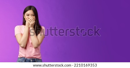 Cute carefree happy young asian girlfriend fooling around, giggle, close mouth palms not laugh loud, acting silly childish, joking, blushing receive surprising cute present, stand purple background Foto d'archivio © 