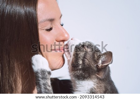 Cute cat kissing woman's nose. Pets love, friendship, trust and lifestyle concept.