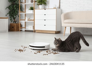 Cute cat with modern robot vacuum cleaner and scattered food at home