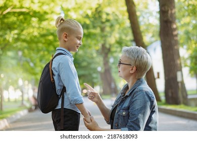 Cute Caucasian Blonde Boy With Ponytail Going To School. Mother Having A Conversation With Child, Saying Goodbye And Givng Advice. Back To School Concept