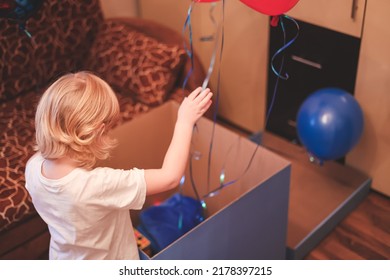 Cute Caucasian  Blonde Five Years Boy Child Opening Birthday Gift Present Box In His Room Home. Lifestyle. Birthday Party For Kids.