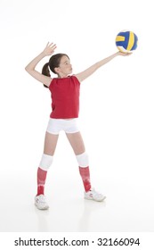 Cute Caucasian girl serving the ball in volleyball isolated on a white background