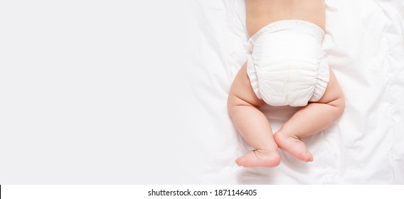 Bebé caucásico lindo con pañal blanco en una manta gris claro. Vista superior. Formato del cartel. Copiar espacio. Cambio de pañales y cuidado de la piel del bebé. 