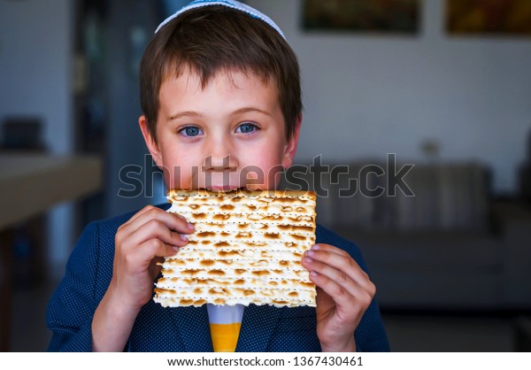 伝統的なユダヤ人のマッツォの種なしパンをかじり 手に持って一口食べる白人ユダヤ人の少年 ユダヤ人の過ぎ越しの人のコンセプト画像 の写真素材 今すぐ編集