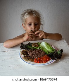 Cute Caucasian Little Girl Eating Helpthy Vegetarian Food. Red Quinoa And Falafel With Tomato Sauce.