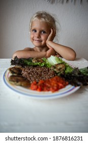 Cute Caucasian Little Girl Eating Helpthy Vegetarian Food. Red Quinoa And Falafel With Tomato Sauce.