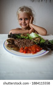 Cute Caucasian Little Girl Eating Helpthy Vegetarian Food. Red Quinoa And Falafel With Tomato Sauce.