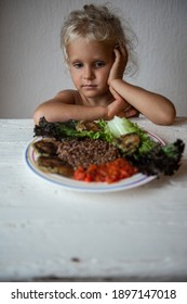 Cute Caucasian Little Girl Eating Helpthy Vegetarian Food. Red Quinoa And Falafel With Tomato Sauce.