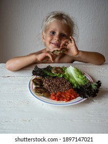 Cute Caucasian Little Girl Eating Helpthy Vegetarian Food. Red Quinoa And Falafel With Tomato Sauce.