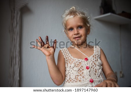 Cute caucasian little girl eating homemade raw dark chocolate. 