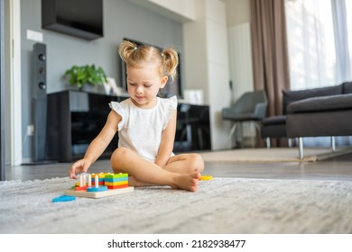 Cute Caucasian Little Girl Playing On The Floor At Home With Eco Wooden Toys. Montessori Toy. The Child Playing Educational Games. High Quality Photo