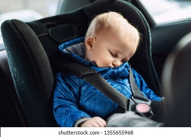 Cute Caucasian Toodler Boy Sleeping In Child Safety Seat In Car During Road Trip. Adorable Baby Dreaming Asleep In Comfortable Place During Journey In Vehicle. Children Care And Safety On Road