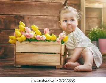 Cute Child Baby Girl With A Bouquet Of Tulips. Mothers Day, Spring Concept.