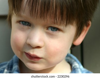 Cute child with blue eyes, close-up, and looking mischievous